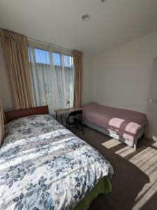 オークランドにあるNewmarket Homestay - Twin Roomのベッドと窓のある寝室