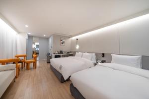 釜山にあるNo 25 Hotelのベッド2台と机があるホテルの部屋