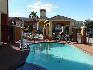 a swimming pool in front of a house at Regency Inn & Suites - Baytown in Baytown
