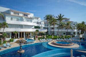 a resort with two pools and chairs and a building at SUNSET FISHERMEN BEACH & SPA RESORT-Optional All Inclusive- 3 UNITS CHOICE-ROOM - 344A Ocean view with terrace- ROOM 344B No terrace, View from window to park - STUDIO 344C Ocean View Studio for 2- Playacar, Phase 1 in Playa del Carmen