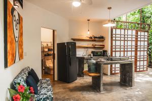a kitchen with a black refrigerator and a table at Peaceful Jungle Villa Cooper - Pool & Parking for 2 persons in Puerto Viejo