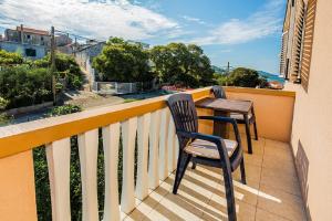 a balcony with two chairs and a table at Apartment Kreso in Tkon