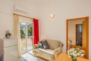 a living room with a chair and a window at Apartment Kreso in Tkon