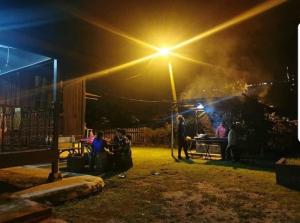 a group of people sitting in a yard at night at Sea View Kampong Style Homestay Pengkalan Balak in Pengkalan Balak