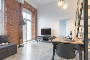 Televízia a/alebo spoločenská miestnosť v ubytovaní Apartament z antresolą Nowa Papiernia