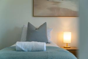 a bed with a pillow and a lamp on a table at Best Day Ever in Wanaka