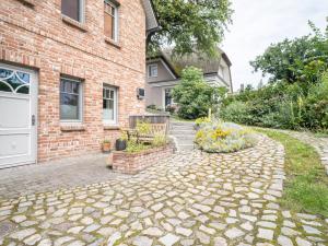 a brick house with a stone driveway at UNS MUUSLOCK in Ahrenshoop +6 photos