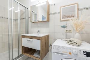 a bathroom with a sink and a washing machine at Ferienwohnung Fehmarn "FeWoFe" in Westfehmarn