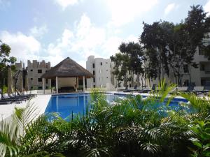 a swimming pool with a gazebo and buildings at Gigi's Caribbean Paradise Aparment in Playa del Carmen
