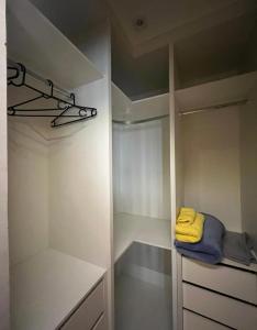 a walk in closet with white cabinets and a yellow towel at Quarto na Asa sul in Brasilia