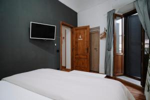 a bedroom with two beds and a flat screen tv at Bonne Nuit Terracina in Terracina