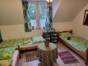 a room with two beds and a table in it at PYZÓWKA - agroturystyka, dom na zaciszu, imprezy in Raków