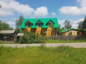 a house with a green roof on the side of a road at PYZÓWKA - agroturystyka, dom na zaciszu, imprezy in Raków