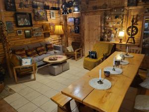 a living room with a table and a couch at PYZÓWKA - agroturystyka, dom na zaciszu, imprezy in Raków