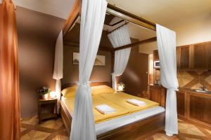 a bedroom with a canopy bed with white curtains at Penzion V Roklich & Apartments V Roklich in Ricany