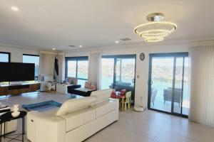 a living room with a white couch and a tv at Tranquil Riverfront Oasis in Oatley