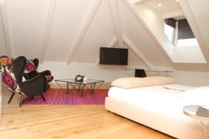 a living room with a bed and a table and a tv at Solar Do Castelo - Melgaço in Melgaço
