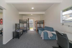 a living room with a blue couch and a window at Across the Road to the Beach - Beach House in Whitianga