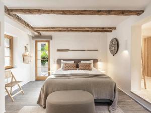 a white bedroom with a large bed and a chair at Villa in Andratx with Sea Views and Pool in Andratx +32 photos