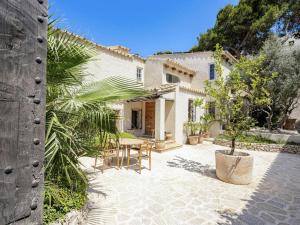 a courtyard of a house with a table and chairs at Villa in Andratx with Sea Views and Pool in Andratx