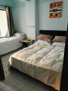 a bedroom with a bed and a couch at ZNZ Oasis Homestay in Port Dickson