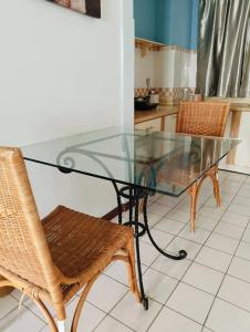 a glass table and chairs in a kitchen at ZNZ Oasis Homestay in Port Dickson
