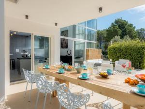 a dining room with a wooden table and chairs at Villa in Cala Vadella near Es Vedrà Views in Cala Vadella