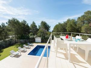 a patio with a table and chairs and a swimming pool at Villa in Cala Vadella near Es Vedrà Views in Cala Vadella
