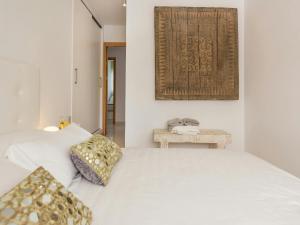 a white bedroom with a bed and a table at Villa in Cala Vadella near Es Vedrà Views in Cala Vadella +32 photos