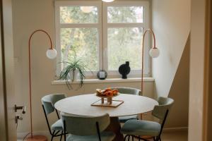 a dining room with a table and chairs and a window at Villa Haag - Wohnflair Apartments nah am Dom in Fulda +28 photos