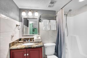 a bathroom with a sink and a toilet and a mirror at Wind Drift 114 North by Vacation Homes Collection in Orange Beach