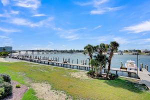 a dock with a boat in a body of water at Wind Drift 114 North by Vacation Homes Collection in Orange Beach +17 photos
