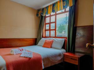 a bedroom with two beds and a window at Hotel COTURPA in Papallacta