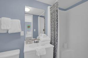 a bathroom with a sink and a toilet and a mirror at Wind Drift 501 by Vacation Homes Collection in Orange Beach