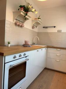 a kitchen with white cabinets and a stove top oven at Charming Studio Retreat in the Heart of Zagreb in Zagreb