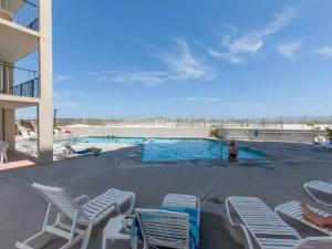 a swimming pool with lounge chairs and a beach at Wind Drift 501 by Vacation Homes Collection in Orange Beach +31 photos