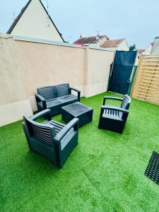 3 sillas y mesas en un jardín en un patio trasero en La belle échappée Auxerre Centre, en Auxerre