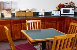 cocina con mesa, sillas y barra en Country Hearth Inn-Union City en Union City