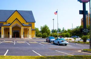 un edificio giallo con auto parcheggiate in un parcheggio di Country Hearth Inn-Union City a Union City