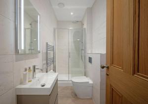 a bathroom with a shower and a toilet and a sink at The Byron Suite in Lichfield