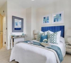 a bedroom with a bed with blue and white pillows at The Byron Suite in Lichfield