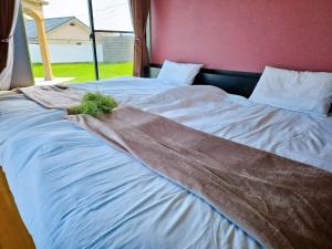 a bed with a blanket on top of it at Shima City Detached house SKO1 in Katada