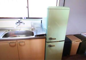 an old refrigerator next to a sink in a kitchen at Shima City Detached house SKO1 in Katada +33 photos