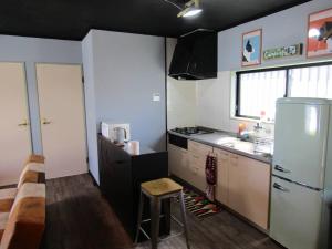 a small kitchen with a refrigerator and a sink at Shima City Detached house SKO1 in Katada
