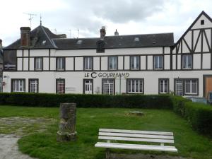 a white building with a bench in front of it at Le C Gourmand in Sées