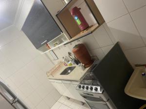 a small kitchen with a sink and a stove at Hostel Gonzales in Votorantim +3 photos