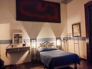 a bedroom with a bed and a painting on the wall at Villa Catrina in Morelia +7 photos