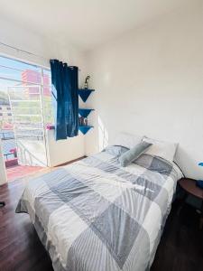 ein Schlafzimmer mit einem Bett und einem großen Fenster in der Unterkunft Linda Habitación en Centro Histórico en Ciudad de Mexico in Mexiko-Stadt