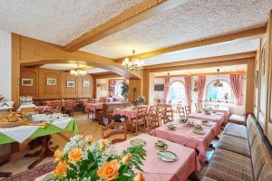 un restaurant avec tables et chaises et nappes roses dans l'établissement Pension Sonneneck, à Bayerisch Eisenstein