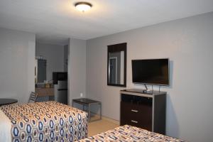 a hotel room with two beds and a flat screen tv at Woodfield Inn and Suites in Yoakum